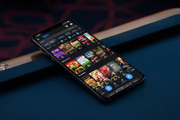 TAS71 App — Enjoy seamless gaming on your smartphone A young woman relaxing with her phone while dynamic casino elements float around her, illustrating the smooth mobile experience offered by the TAS71 app.